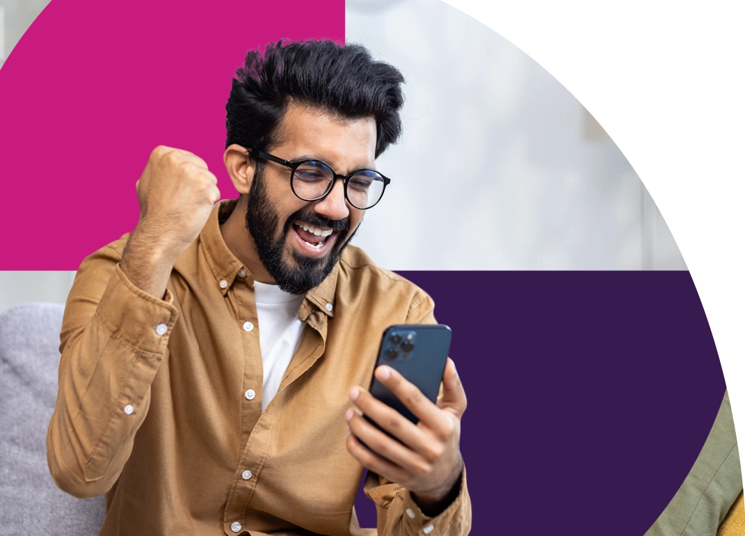 Man holding phone and raising fist in air, excited knowing savings are secure with Saven Financial.
